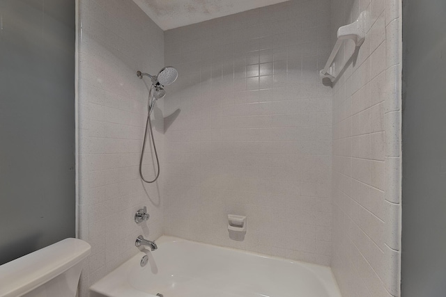 bathroom with tiled shower / bath and toilet