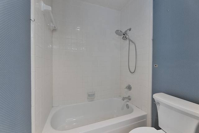 bathroom with tiled shower / bath and toilet