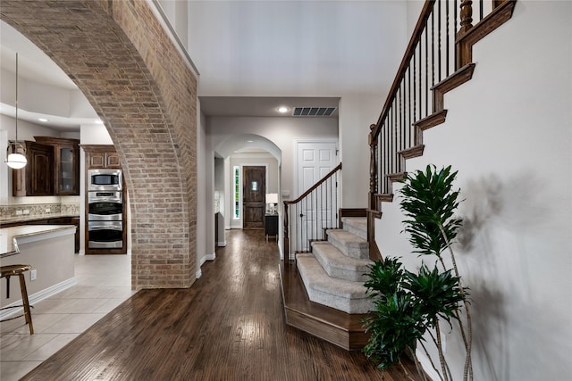 entryway featuring a high ceiling and wood-type flooring