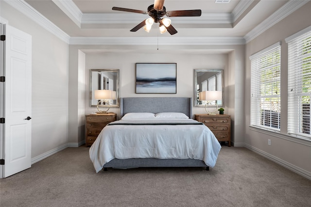 carpeted bedroom with crown molding, a tray ceiling, and ceiling fan