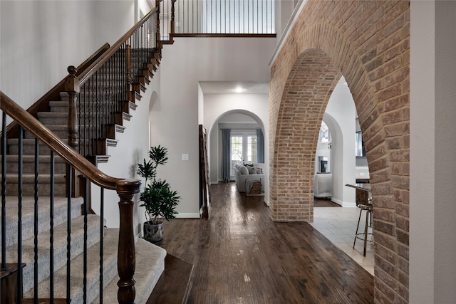 foyer featuring a towering ceiling and hardwood / wood-style floors