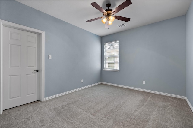 carpeted spare room with ceiling fan