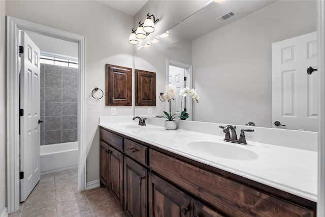 bathroom featuring tile patterned flooring, vanity, and tiled shower / bath combo