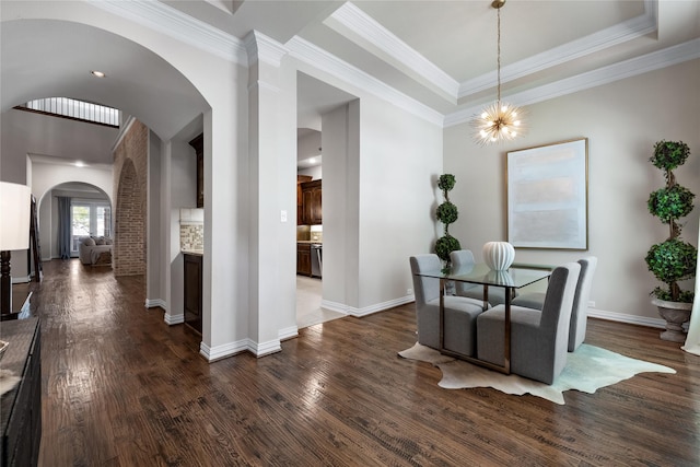 dining area with dark hardwood / wood-style floors, ornamental molding, and a raised ceiling