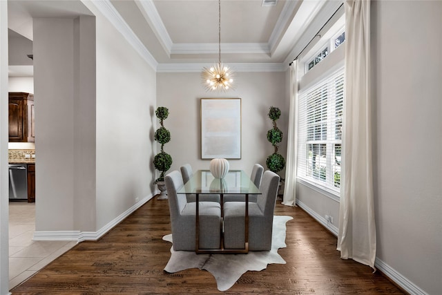 dining area with crown molding, dark hardwood / wood-style floors, a notable chandelier, and a tray ceiling