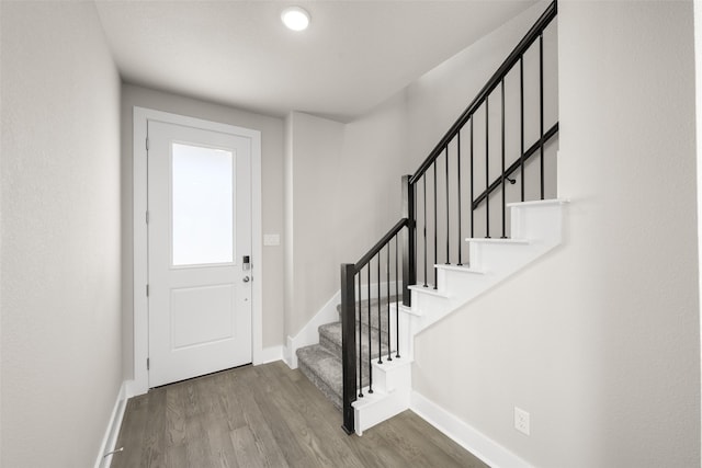 foyer entrance with stairway, wood finished floors, and baseboards