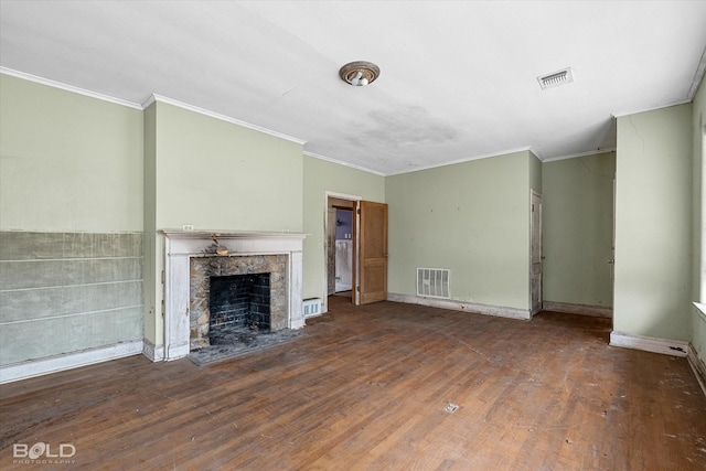 unfurnished living room featuring dark hardwood / wood-style flooring, a stone fireplace, and ornamental molding