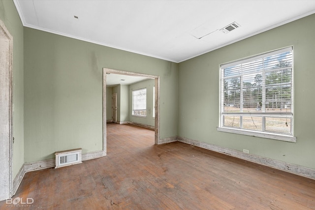 empty room featuring hardwood / wood-style floors and crown molding