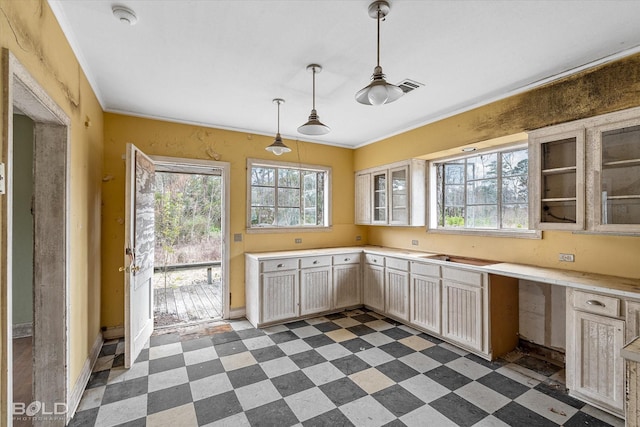 kitchen featuring hanging light fixtures, crown molding, and built in desk