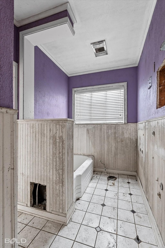 bathroom featuring ornamental molding and wood walls