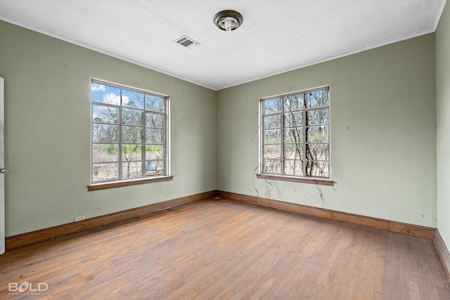 unfurnished room with ornamental molding and light wood-type flooring