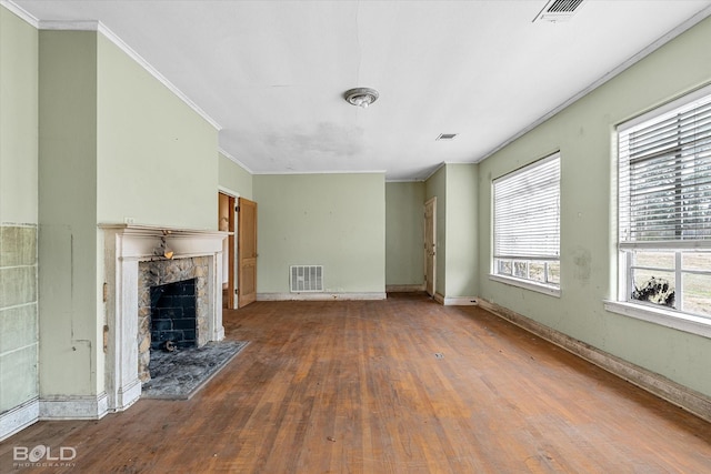 unfurnished living room with crown molding, wood-type flooring, and a fireplace