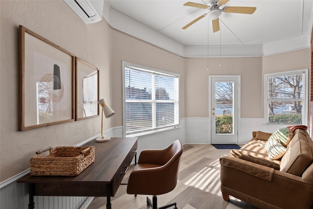 office space with ceiling fan, a wall mounted air conditioner, and light hardwood / wood-style flooring