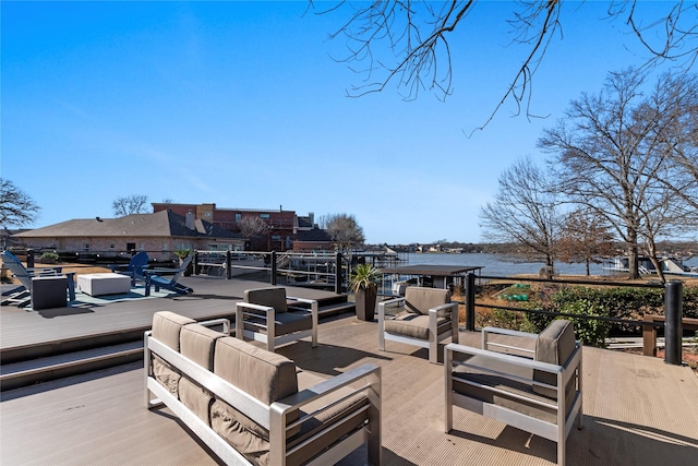 wooden deck with a water view and outdoor lounge area