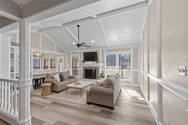 living room featuring ornate columns, high vaulted ceiling, beamed ceiling, ceiling fan, and light hardwood / wood-style floors