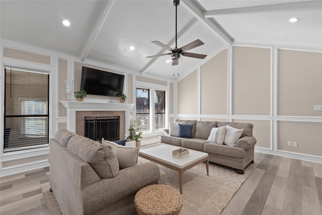 living room featuring ceiling fan, lofted ceiling with beams, and light hardwood / wood-style flooring