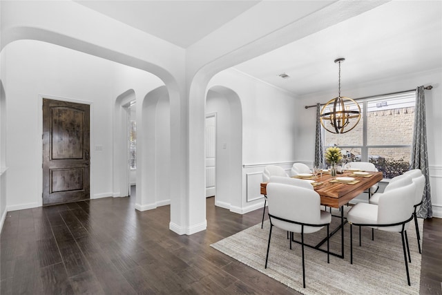 dining room featuring ornamental molding, dark hardwood / wood-style flooring, and a chandelier