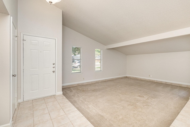 carpeted entryway with vaulted ceiling and a textured ceiling