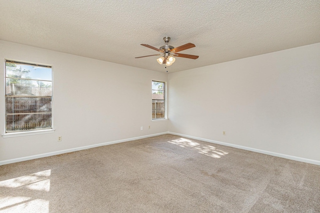 carpeted empty room featuring ceiling fan and a textured ceiling