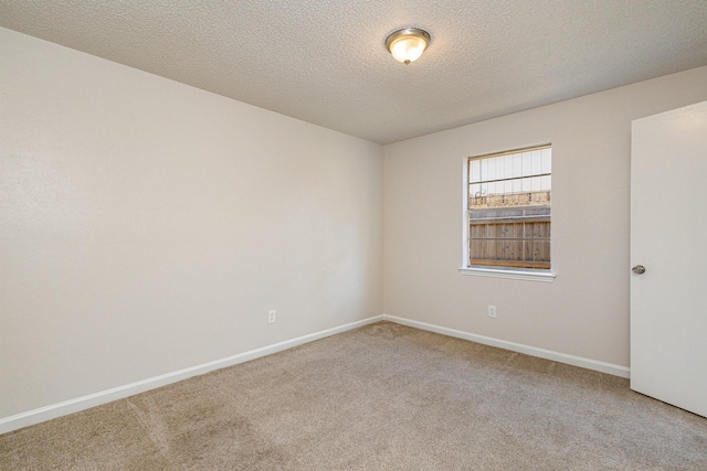 carpeted spare room featuring a textured ceiling