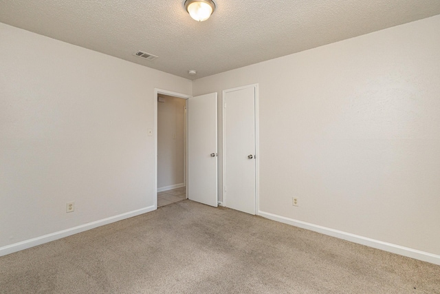 spare room with carpet and a textured ceiling