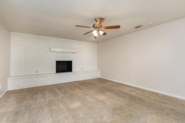 unfurnished living room featuring ceiling fan, carpet, a textured ceiling, and a fireplace