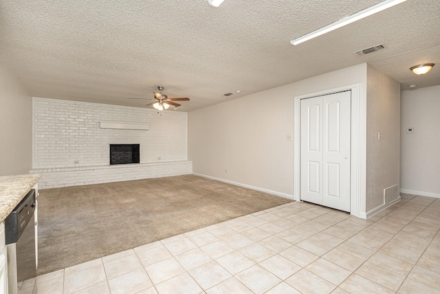 unfurnished living room featuring light carpet, a brick fireplace, a textured ceiling, and ceiling fan