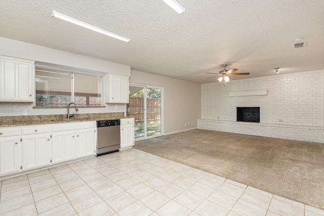 kitchen featuring dishwasher, sink, light colored carpet, and white cabinets