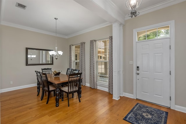 dining room featuring ornate columns, plenty of natural light, a notable chandelier, and light hardwood / wood-style floors