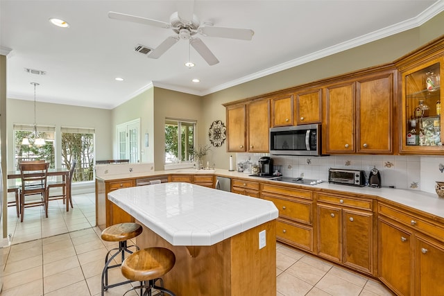 kitchen featuring a kitchen island, a kitchen breakfast bar, decorative backsplash, hanging light fixtures, and light tile patterned floors