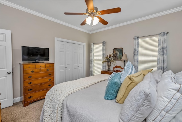 bedroom featuring ornamental molding, light colored carpet, ceiling fan, and a closet