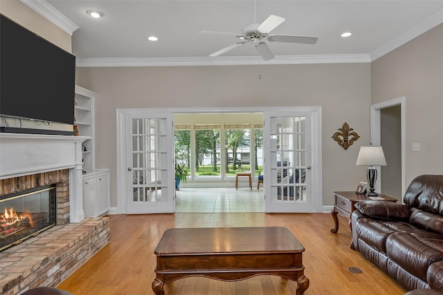 living room with crown molding, ceiling fan, and light hardwood / wood-style floors