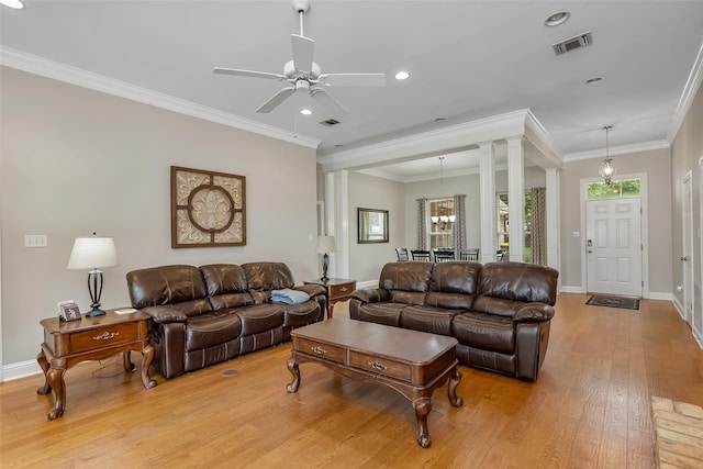 living room featuring decorative columns, crown molding, ceiling fan, and light wood-type flooring