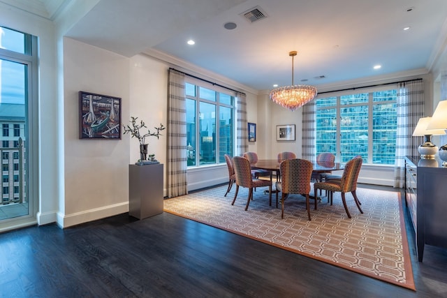 dining area with dark hardwood / wood-style flooring, crown molding, and a chandelier