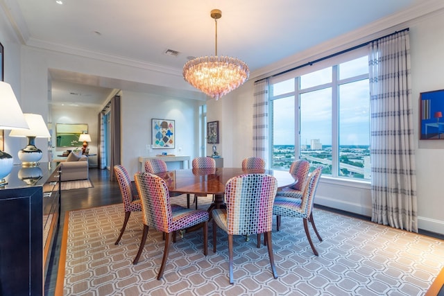 dining room with hardwood / wood-style flooring, ornamental molding, and a notable chandelier