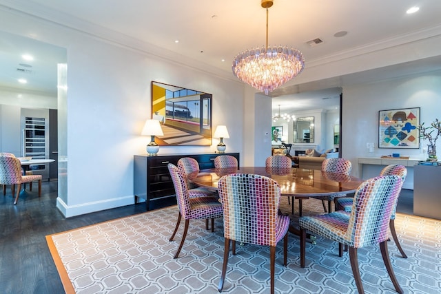 dining room with hardwood / wood-style flooring, ornamental molding, and a chandelier