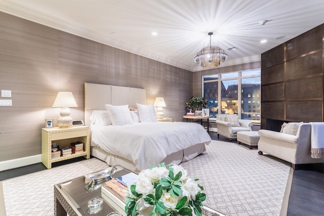 bedroom with an inviting chandelier, ornamental molding, and light hardwood / wood-style floors