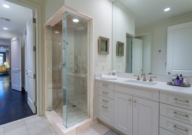 bathroom featuring tile patterned flooring, vanity, crown molding, and a shower with shower door