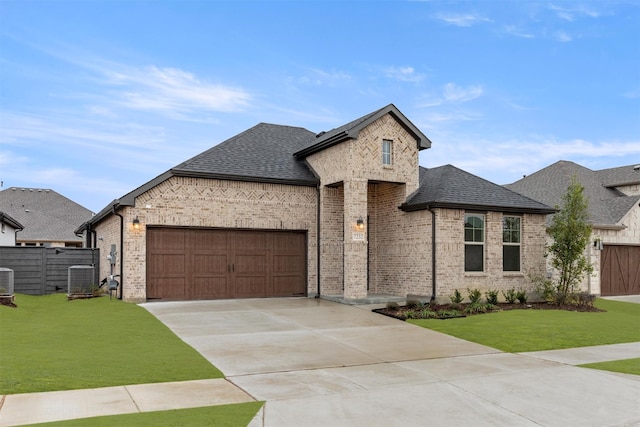 french country inspired facade featuring a shingled roof, a front yard, and brick siding