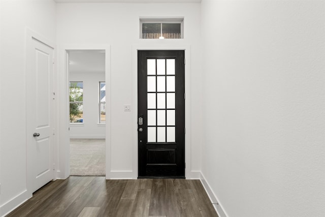 entryway with dark wood-type flooring and baseboards