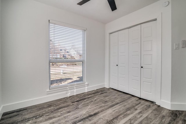 unfurnished bedroom with a closet, ceiling fan, baseboards, and wood finished floors