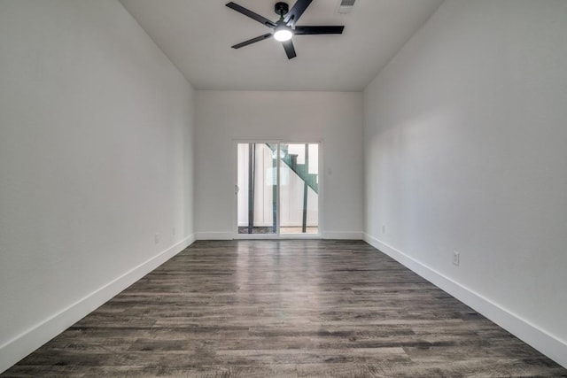 unfurnished room with a ceiling fan, visible vents, baseboards, and dark wood-style flooring