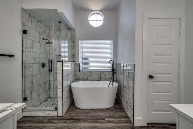 full bathroom featuring a freestanding bath, vanity, a shower stall, and wood finished floors