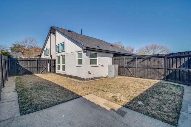 view of property exterior with a yard, central AC unit, and a fenced backyard