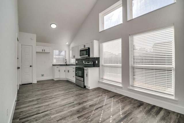 kitchen featuring stainless steel appliances, dark countertops, white cabinetry, and dark wood-style floors