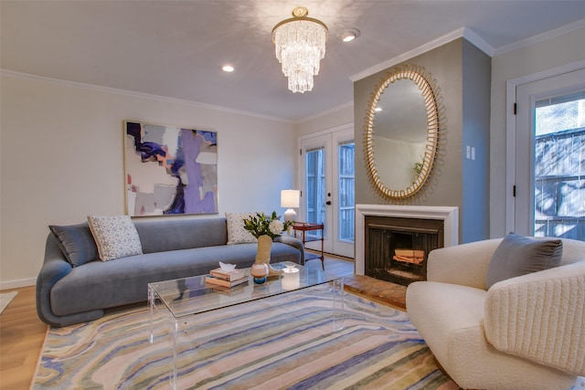 living room with french doors, ornamental molding, wood-type flooring, and a notable chandelier