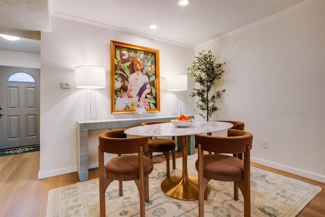 dining area featuring ornamental molding and wood-type flooring