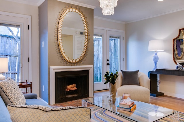 interior space with hardwood / wood-style flooring, crown molding, an inviting chandelier, and french doors