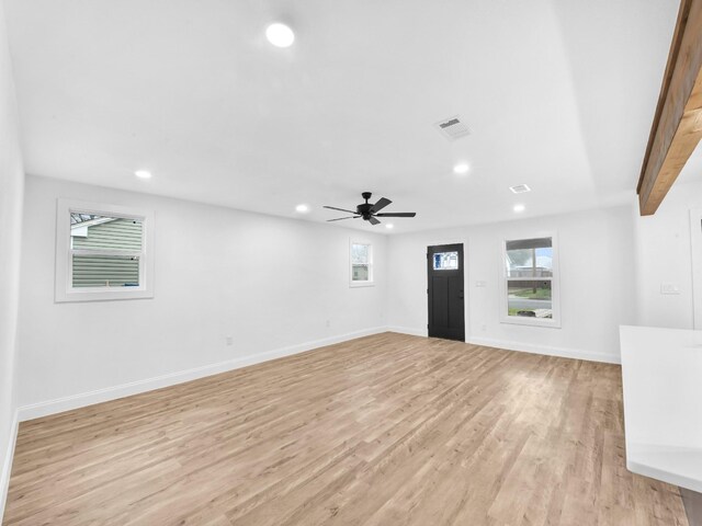 empty room with ceiling fan and light hardwood / wood-style flooring