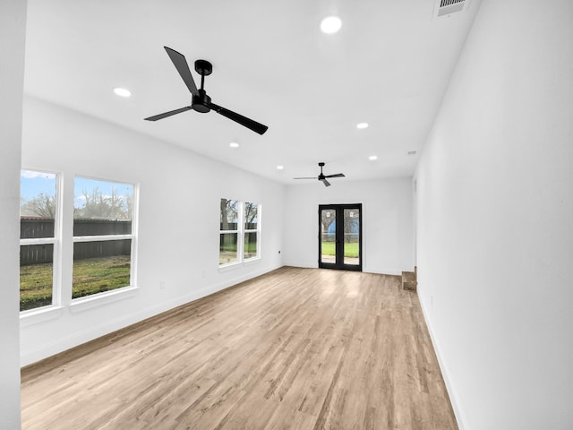 unfurnished living room featuring ceiling fan, light wood-type flooring, and french doors